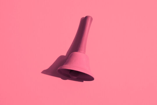 A pink bell on a pink background. Monochromatic composition