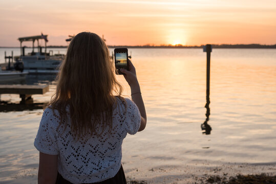 Girl taking a sunset photo