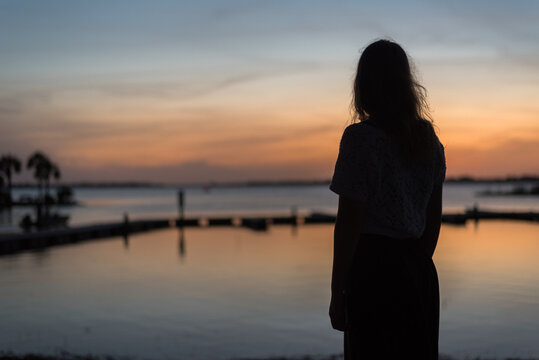 Silhouette of a girl by a lake