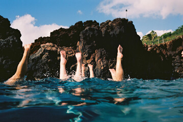 diving feet above ocean with rock in hawaii