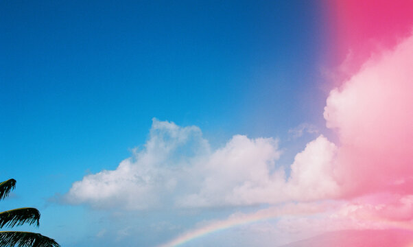 rainbow in blue sky with pink