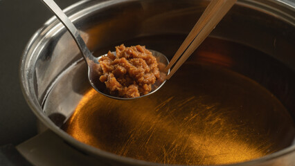 出汁に味噌を溶かす　和食の味噌汁を作るイメージ
