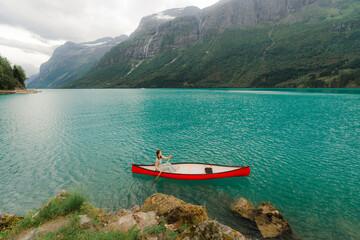 Woman canoeing on turquoise lake in Norway 
