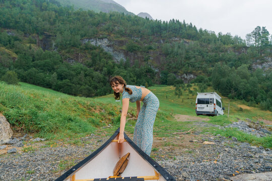 POV of woman getting canoe out of the water 