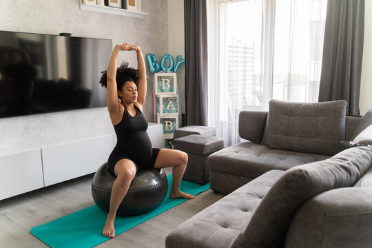 Pregnant Woman Stretching Using Ball At Home