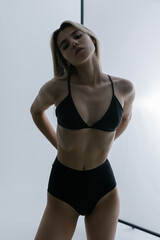 Obraz premium Young sexy pretty girl in a black swimsuit.