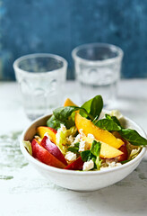 Summer nectarine salad with green leaf vegetables and feta