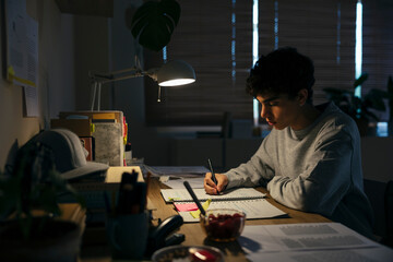 Teenage male studying late night at home
