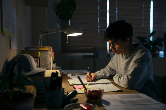 Teenage male studying late night at home