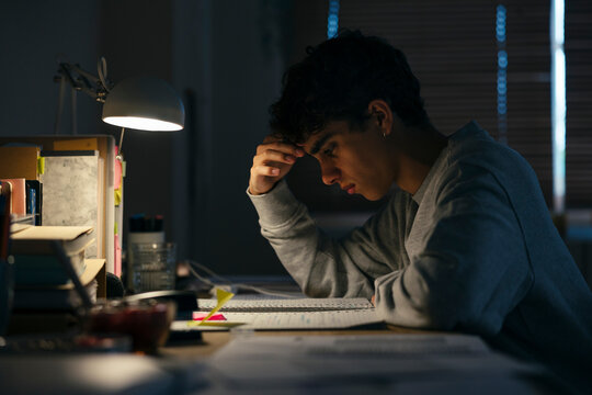 Teenage male studying late night at home