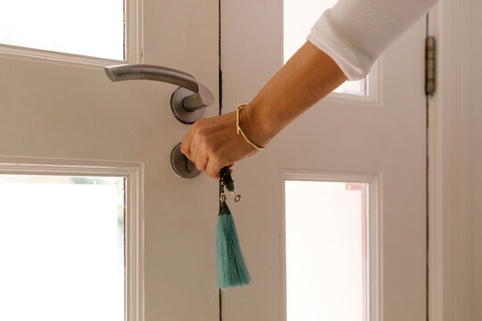 A woman closing a door with a key