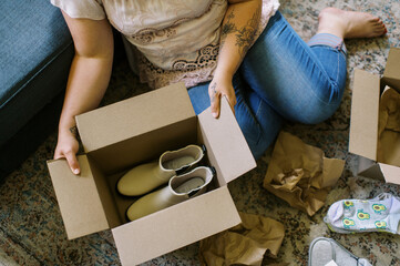 online shopper opening shipping box at home with footwear inside