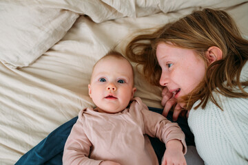 Girl and baby on a bed