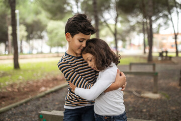 couple of little brothers hugging outdoors
