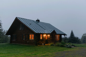 Cozy log cabin cottage home Vermont landscape at dusk in summer 