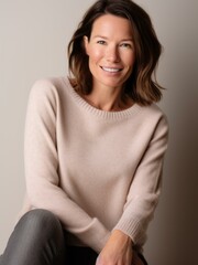 Obraz premium Portrait of a beautiful woman in a beige sweater on a gray background