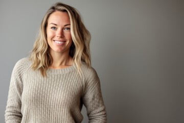 Obraz premium Portrait of a beautiful woman smiling at the camera against grey background