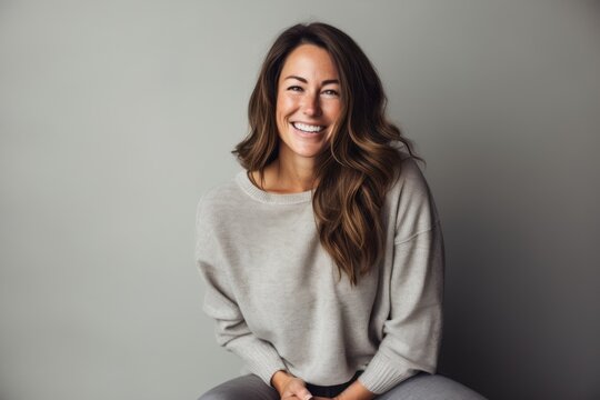 Lifestyle portrait photography of a satisfied woman in her 30s wearing a cozy sweater against a minimalist or empty room background