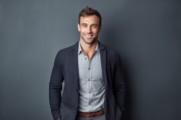 Obraz premium Portrait of a handsome young man standing against grey background, smiling