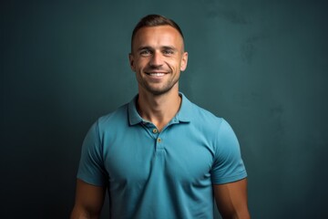 Fototapeta premium Handsome young man in blue polo shirt on grey background
