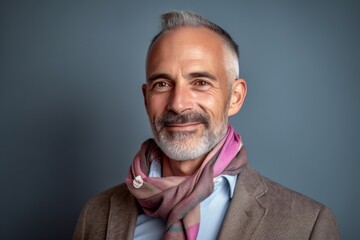 Fototapeta premium Portrait of a handsome mature man with grey hair and beard wearing a coat and scarf.