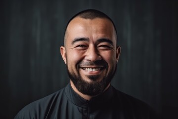 Portrait of a happy young man with a beard on a dark background