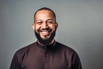 Obraz premium Portrait of a smiling arab man in brown shirt on grey background