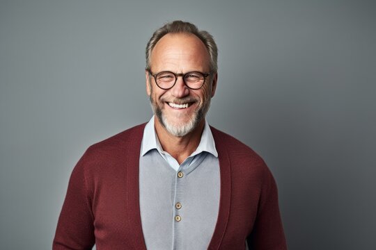 portrait of smiling senior man in eyeglasses isolated on grey