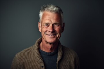 Obraz premium Portrait of a smiling senior man on grey background. Men's beauty, fashion.