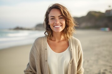 Portrait of smiling young woman standing on beach at the day time