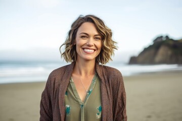 Portrait of smiling woman standing on beach at the beach in the sunshine