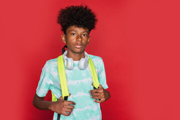 Confident black teen with backpack looking at camera