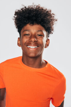 Cheerful black kid with curly hair in studio