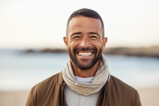 Group portrait photography of a grinning man in his 40s wearing hijab against a beach background