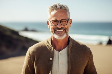 Medium shot portrait photography of a pleased man in his 50s wearing a chic cardigan against a beach background