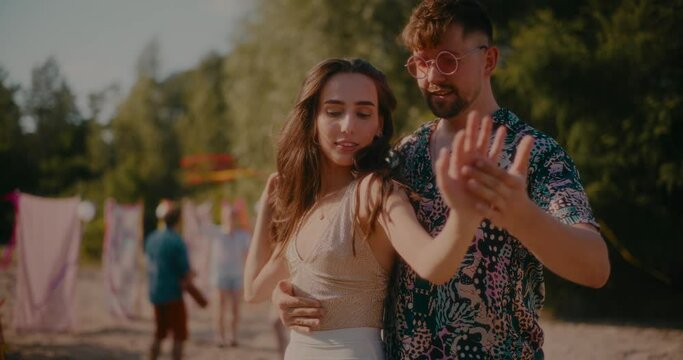 Young woman and man dancing bachata at beach