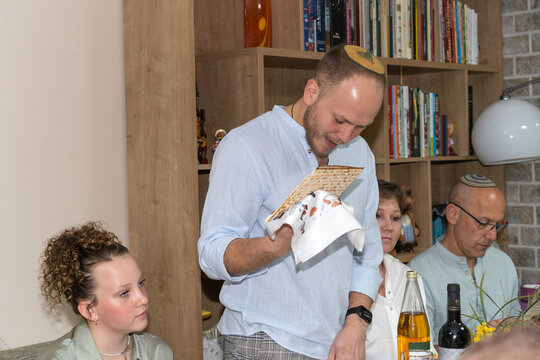Passover Seder Tradition. Man Holding Matzah and Reading Haggadah.