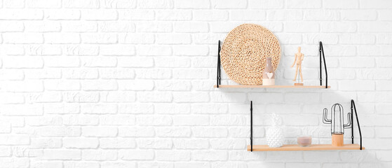 Modern shelves with stylish decor hanging on white brick wall. Banner for design