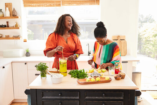 Mature Black women friends making cocktails in the  kitchen