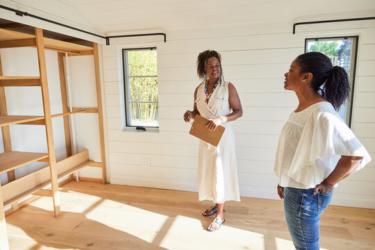 Black real estate agent talking and showing a new home to client