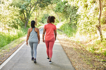 Black girlfriends walking and exercising on a trail together