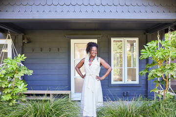 Portrait of mature Black woman new home buyer in front of new house