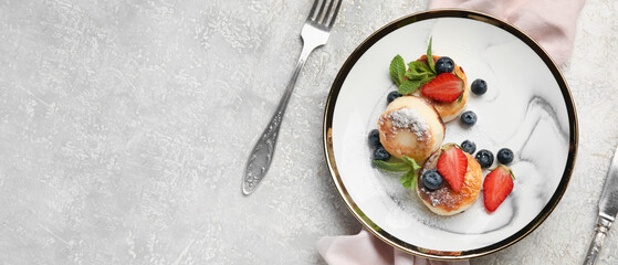 Plate with delicious cottage cheese pancakes and berries on grunge background with space for text