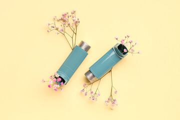 Asthma inhalers with flowers on yellow background