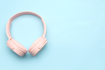Modern pink headphones on blue background