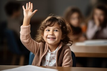 The child raises his hand for an answer in the classroom. Back To School concept. Backdrop with selective focus - obrazy, fototapety, plakaty