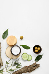 Composition with jar of cream and natural ingredients on light background