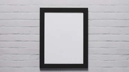 A black frame hanging on a white brick wall