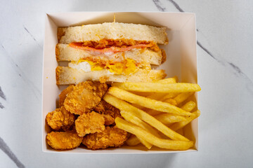top view snack of sandwich and deep fried diced chicken and grape and French fries