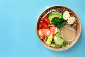 Tasty food in container on light blue background, top view. Space for text